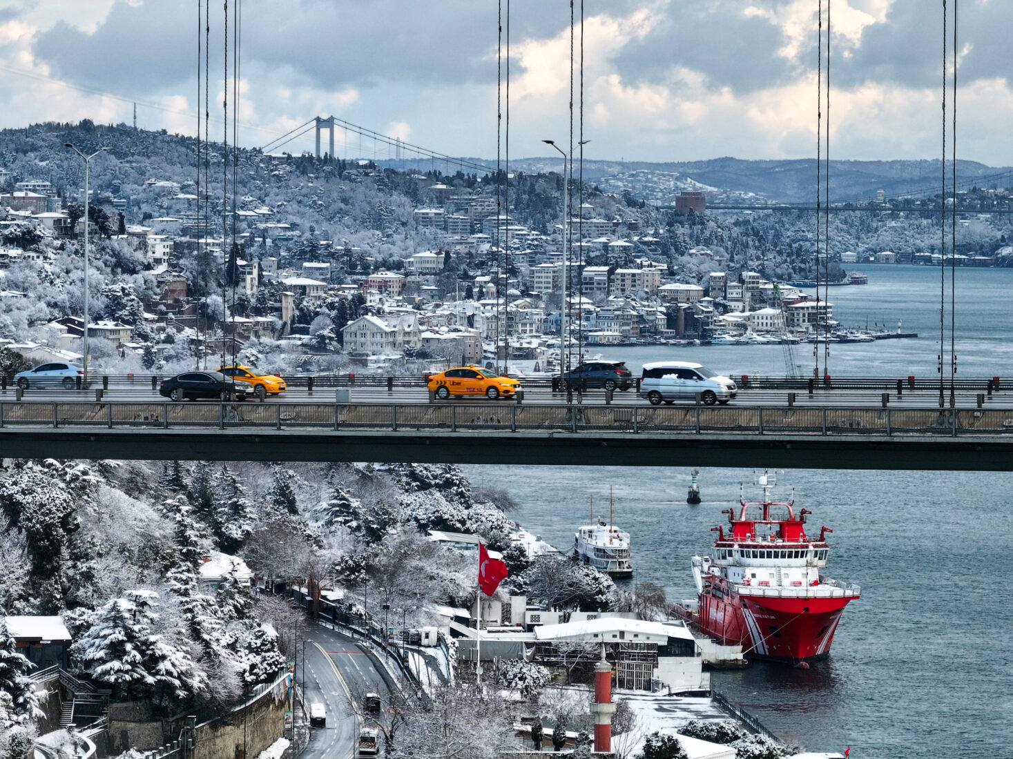 An aerial view shows snow covered residential areas and Bosphorus after intermittent snowfall in Istanbul, Türkiye on February 21, 2025. (AA Photo)