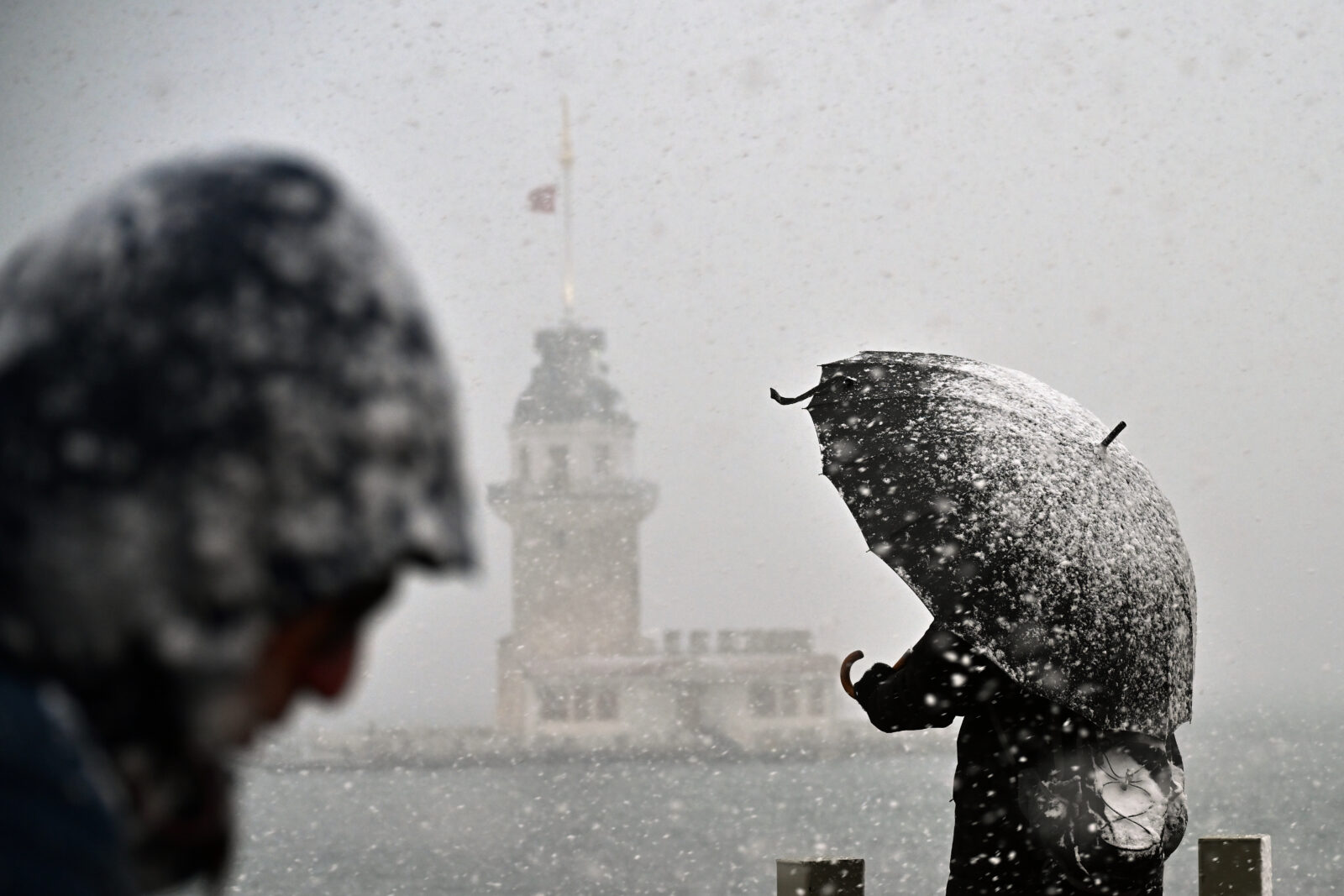 A man shields himself from the snow with an umbrella as the snowfall continues in Uskudar, Istanbul, Türkiye, Feb. 22, 2025. (AA Photo)