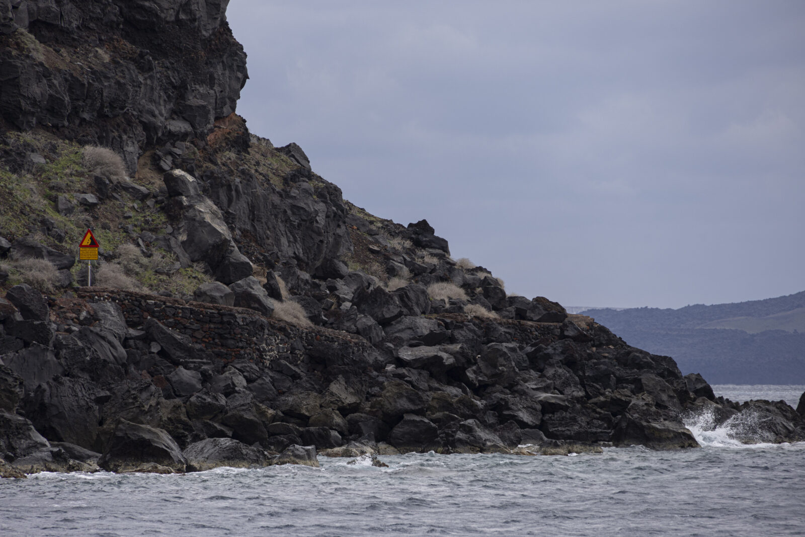 Fallen rocks next to a warning sign in Ammoudi Port, which has been deemed unsafe for use due to the risk of rockfalls and landslides, Santorini Island, Greece, Feb. 21, 2025. (AA Photo)