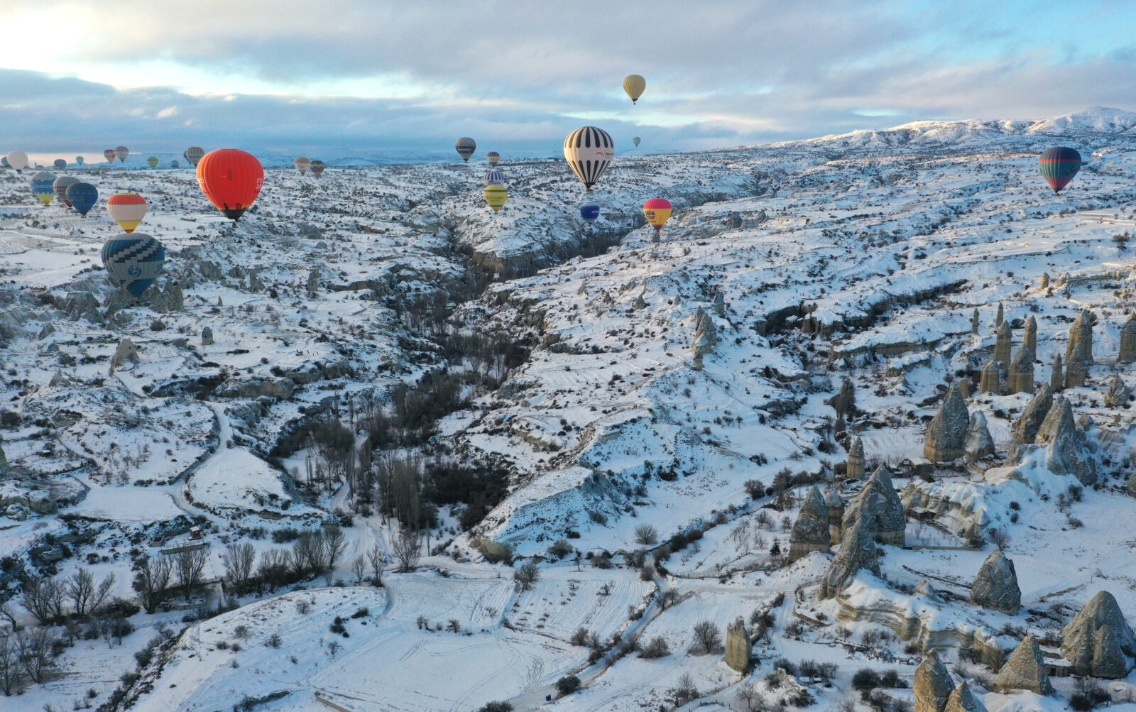 Hot air balloons, grounded for 18 days due to adverse weather conditions in Cappadocia, take to the skies again over the fairy chimneys, covered with a white blanket after snowfall, in Nevsehir, Türkiye, Feb. 23, 2025. (AA Photo)