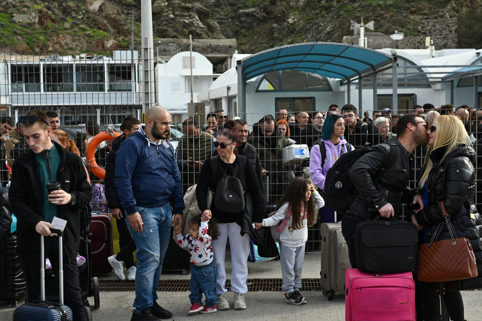 People wait on the quayside to embark on a ferry at the port on the Greek Island of Santorini on February 3, 2025, as they prepare to leave in the wake of recurring earthquakes. Fear of the Santorini volcano eruption led to panic on the island. (AFP Photo)