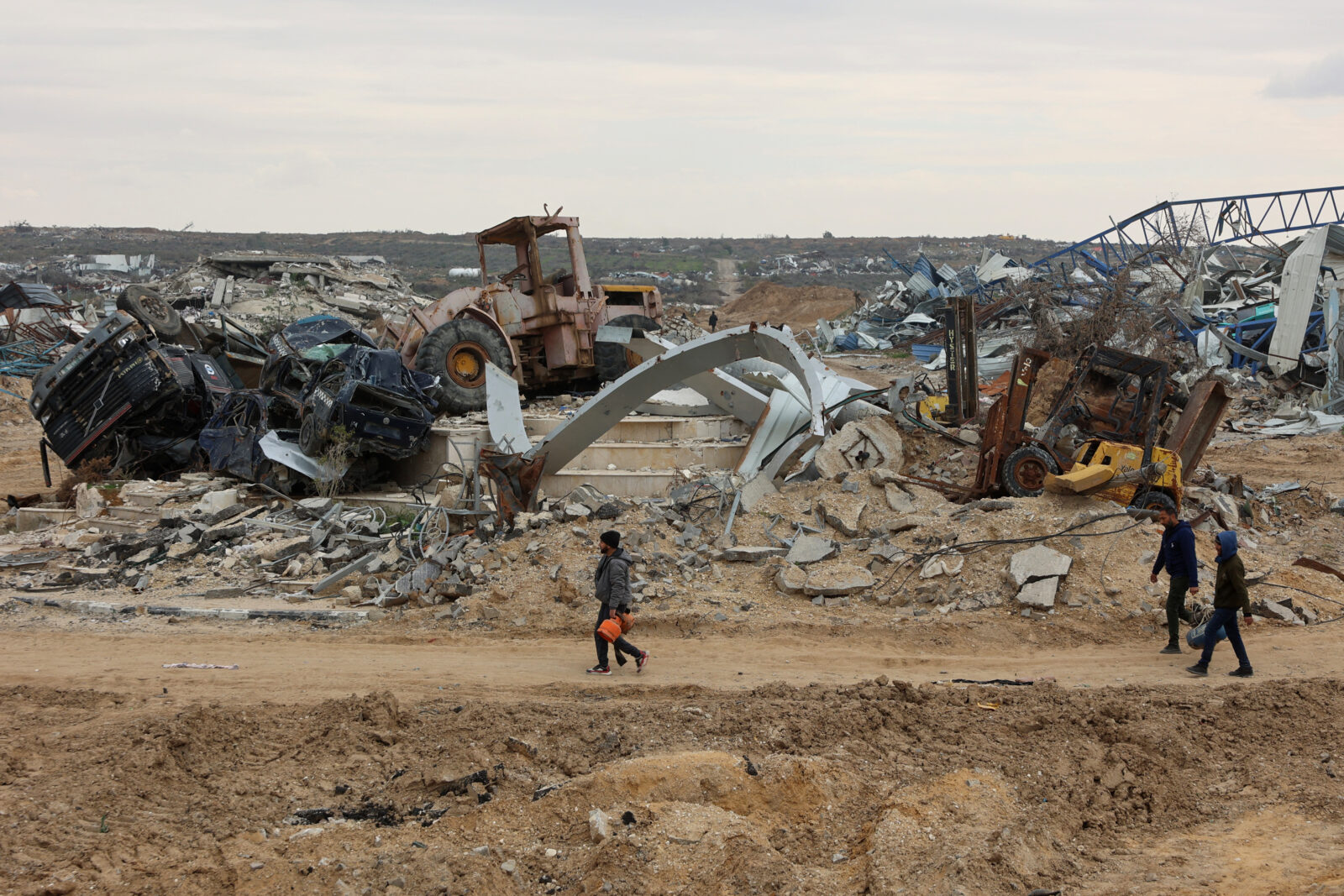 Displaced Palestinians walk past destroyed vehicles as they cross the Netzarim corridor as they make their way to the northern parts of the Gaza Strip on February 9, 2025. (AFP Photo)