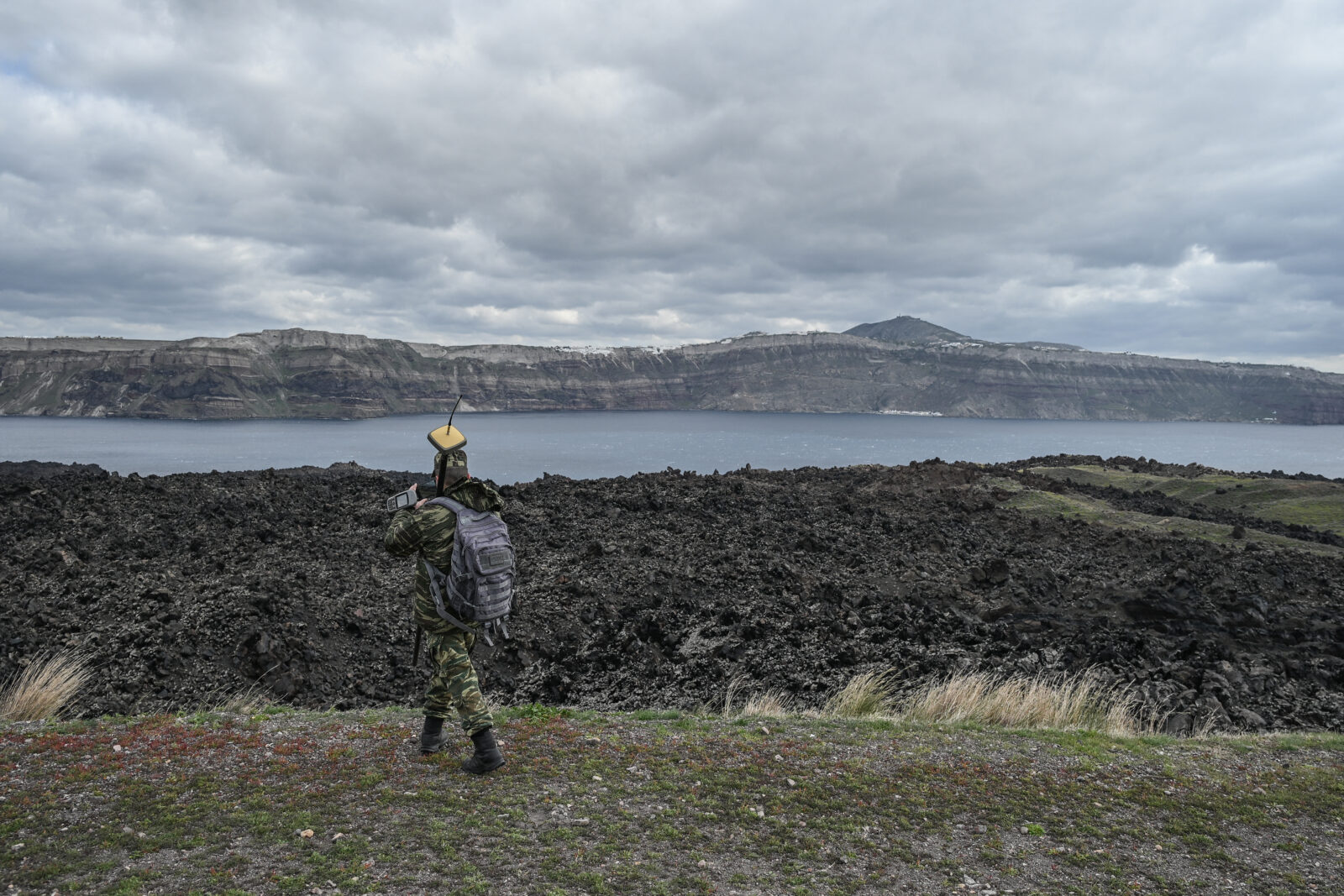 A member of Greece's military geographical service takes measurements on Santorini's volcanic island Nea Kameni to determine if the seismic swarm ongoing in the area since early February have caused any structural changes, on February 10, 2025. (AFP Photo)
