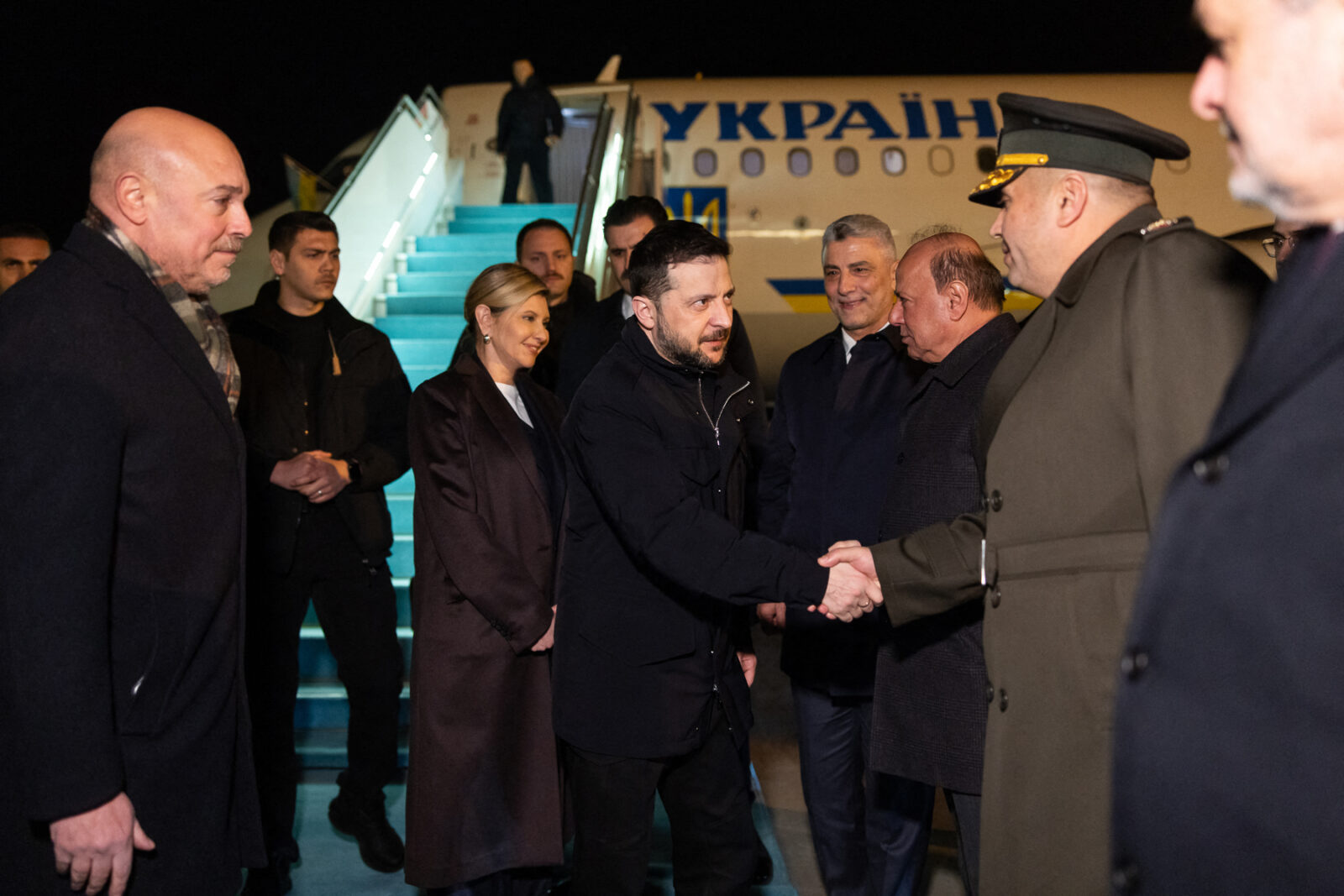 Ukrainian President Volodymyr Zelenskyy (C) shaking hands next to his wife Olena Zelenska (centre L) after their plane landed in Türkiye on February 17, 2025. (Photo by Handout / X account of Volodymyr Zelenskyy / AFP)