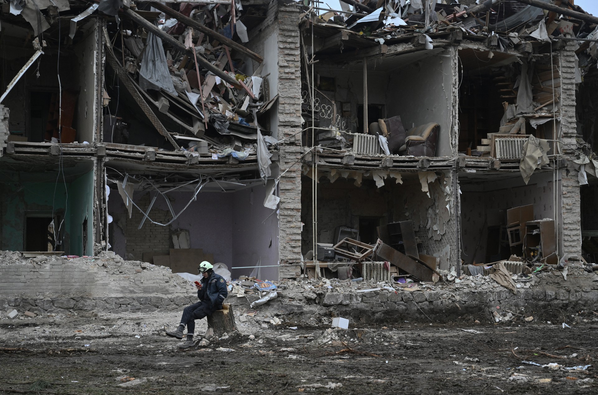 A rescuer sits next to a residential building, heavily damaged few days earlier following a Russian strike in the Zaporizhzhia on January 26, 2025 (AFP Photo)