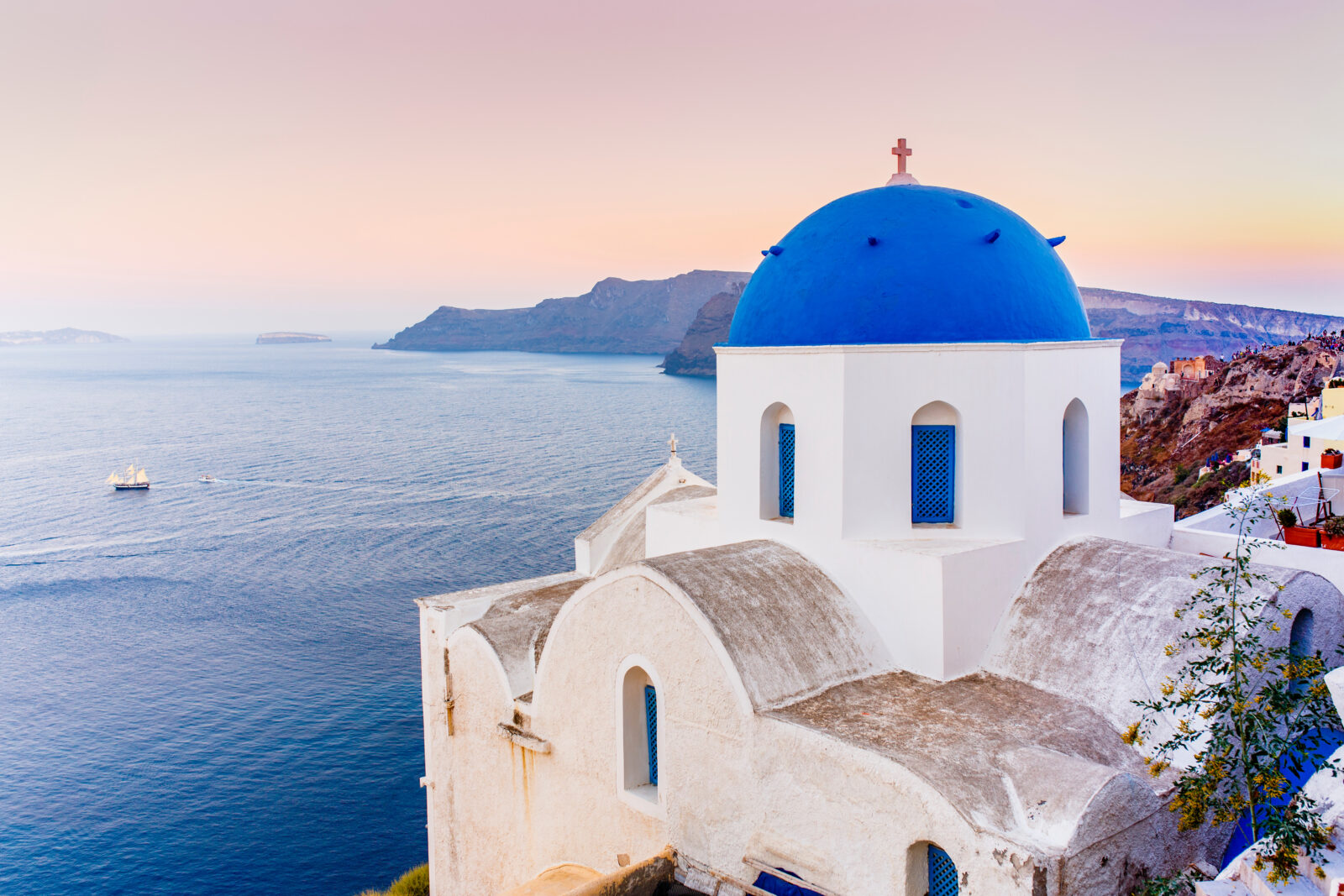 Picturesque view of Old Town Oia on the island Santorini, white houses, windmills and church with blue domes, Greece (Adobe Stock Photo)