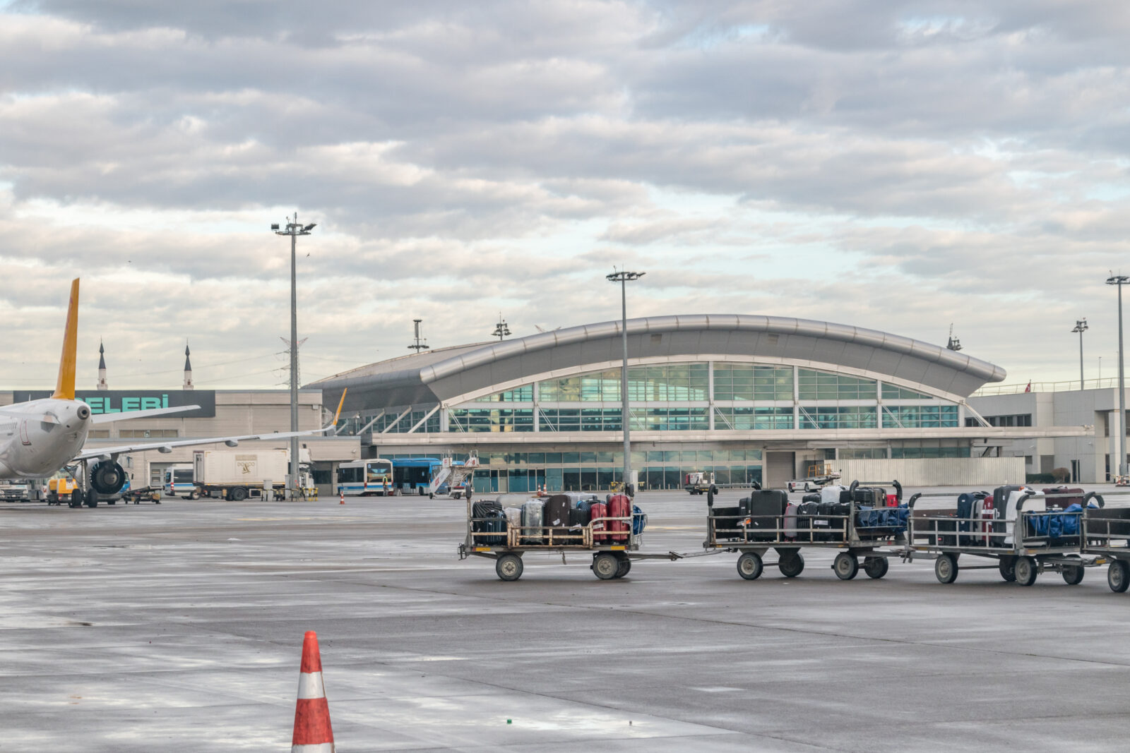 Baggage carts transport luggage across the tarmac at Sabiha Gokcen Airport in Istanbul, Türkiye, on Dec. 12, 2022. (Adobe Stock Photo)