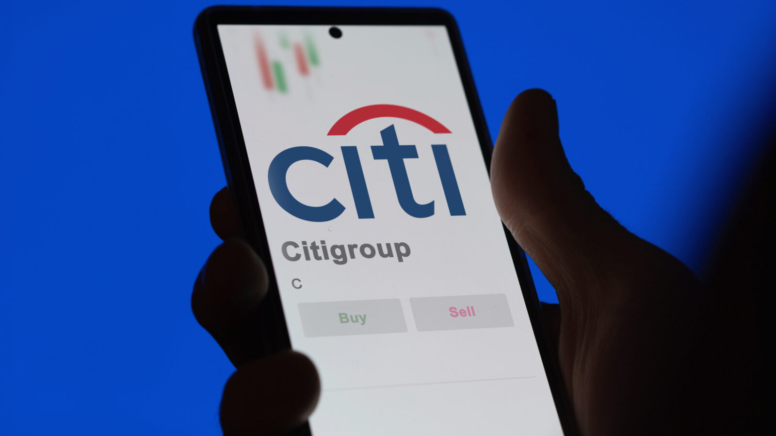 The file photo shows a person holding a smartphone displaying the Citigroup logo on a trading or financial application. (Adobe Stock Photo)