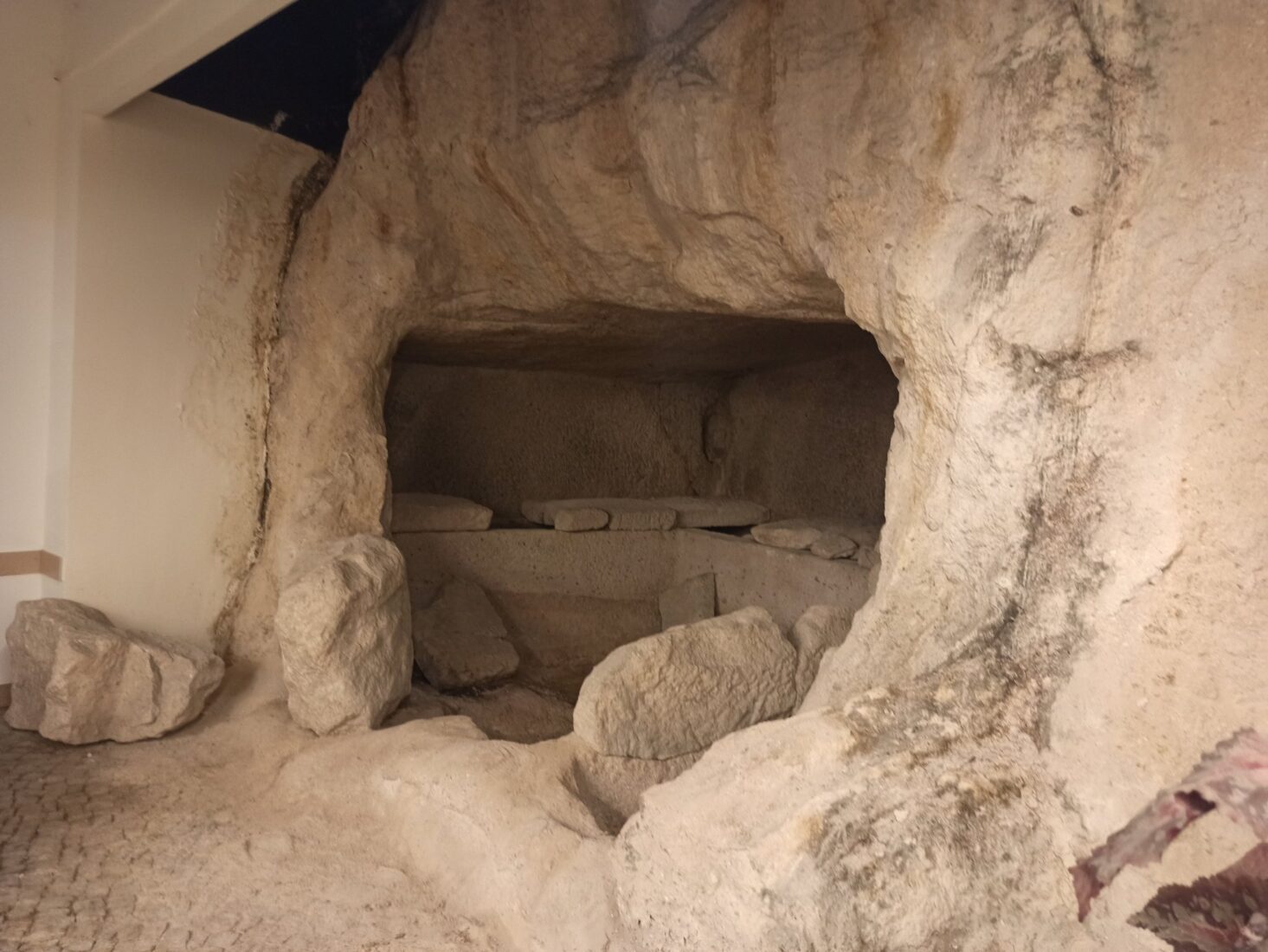 A 2,300-year-old rock-cut tomb, enclosed by barriers, is displayed inside a supermarket. (Photo via X)