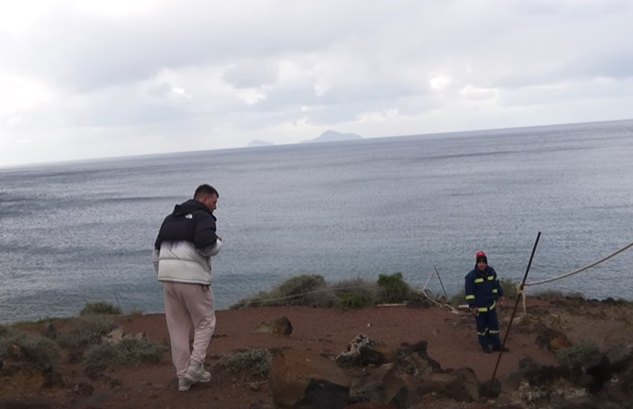 At Red Beach, YouTuber Giannelis (L) encounters a firefighter (R) on duty. (Screenshot from Giannelis' YouTube video)