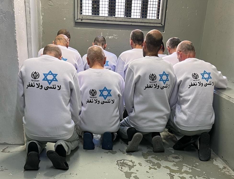 Prisoners wear uniforms with the Star of David and the Arabic phrase 