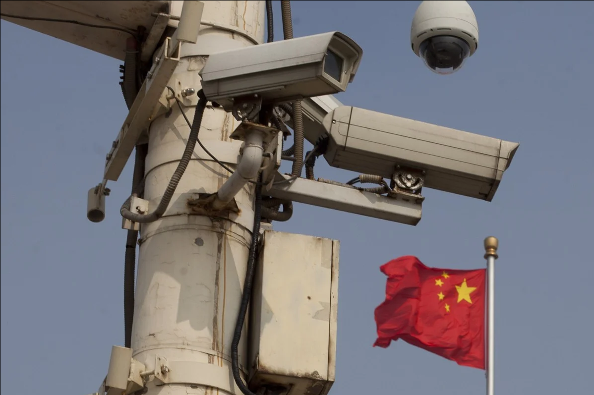 Chinese flag is shown behind public surveillance cameras in China. (AFP Photo)