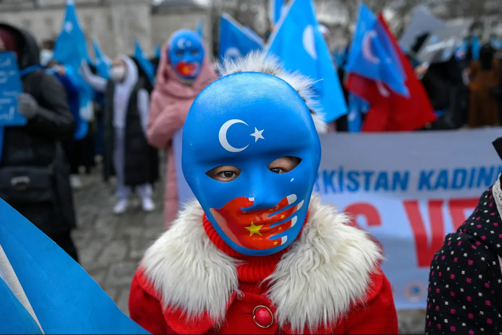 A child from the Uyghur community living in Türkiye wears a mask during a protest against the visit of China's Foreign Minister to Türkiye, in Istanbul on March 25, 2021. (AFP Photo)