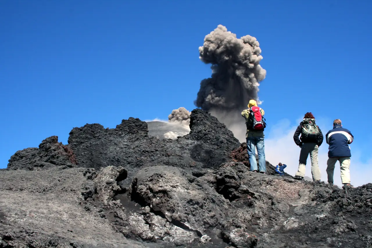 A group of three tourists taking a photo while ash eruptions occur at Mount Etna, Italy. (Photo via Tripadvisor)