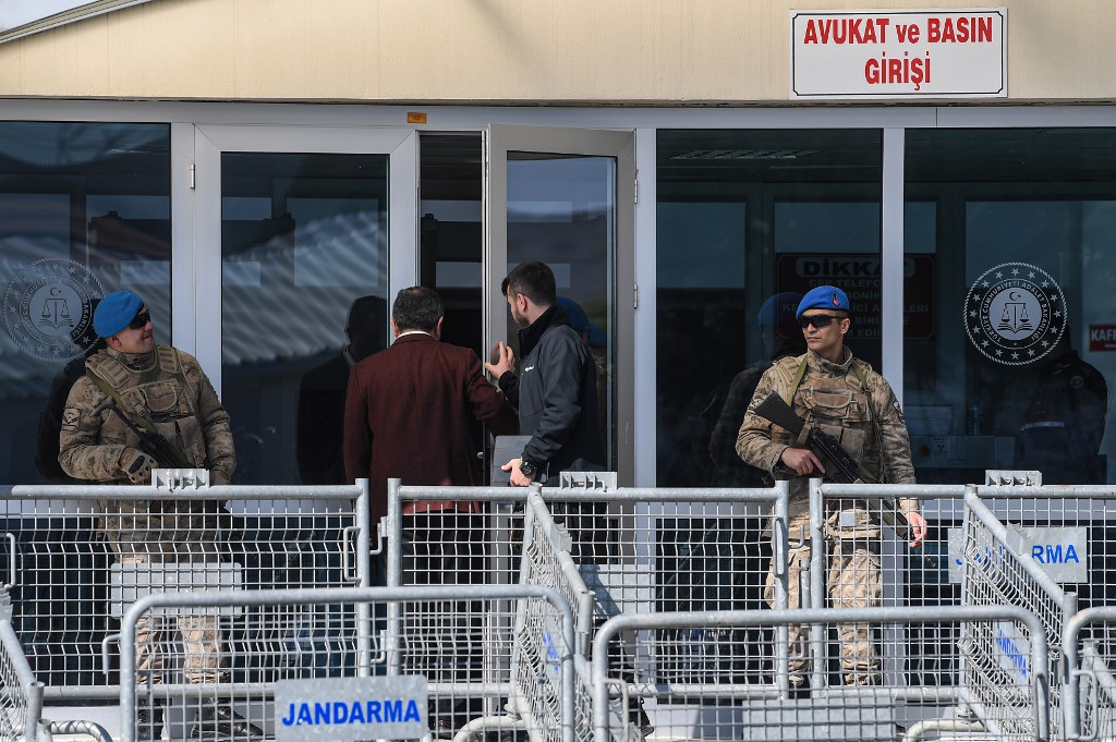 Turkish soldiers stand guard as two men enter the Silivri Prison and Courthouse complex in Silivri, near Istanbul on February 18, 2020 during the trial of Gezi protests and civil society figure Osman Kavala, along with 15 other people, charged with seeking to overthrow the government. (Photo by Ozan KOSE / AFP)