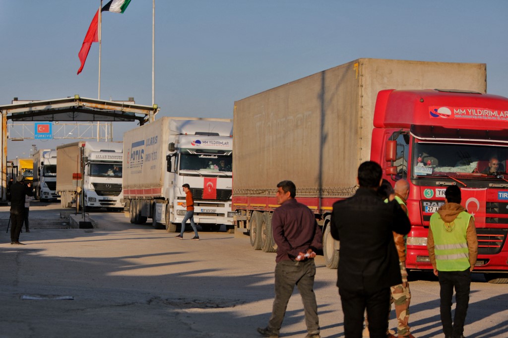 Trucks part of an aid convoy cross from Türkiye into rebel-held north Syria through the Bab al-Salama crossing on February 14, 2023, after it reopened for UN relief after last week's earthquake. - The crossing had been closed for UN aid since 2020, under pressure at the UN Security Council from Syrian regime ally Russia, calling instead for all relief for the war-torn country to enter via government-controlled. (Photo by Bakr ALKASEM / AFP)