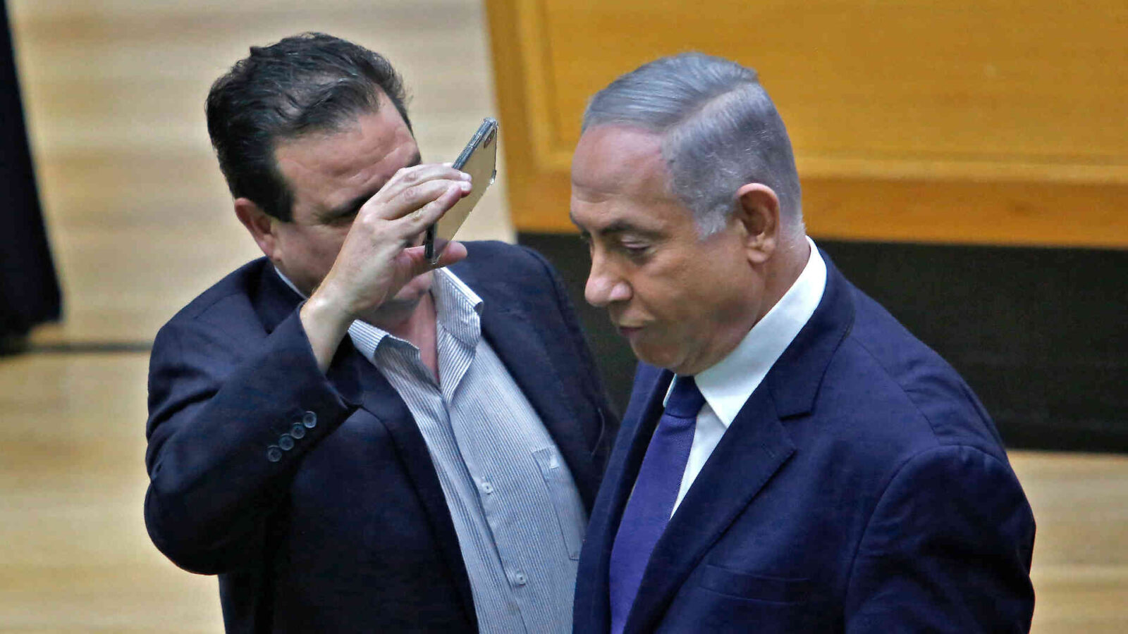 Knesset member Ayman Odeh uses a phone to take a close-up picture of Netanyahu (AFP Photo)