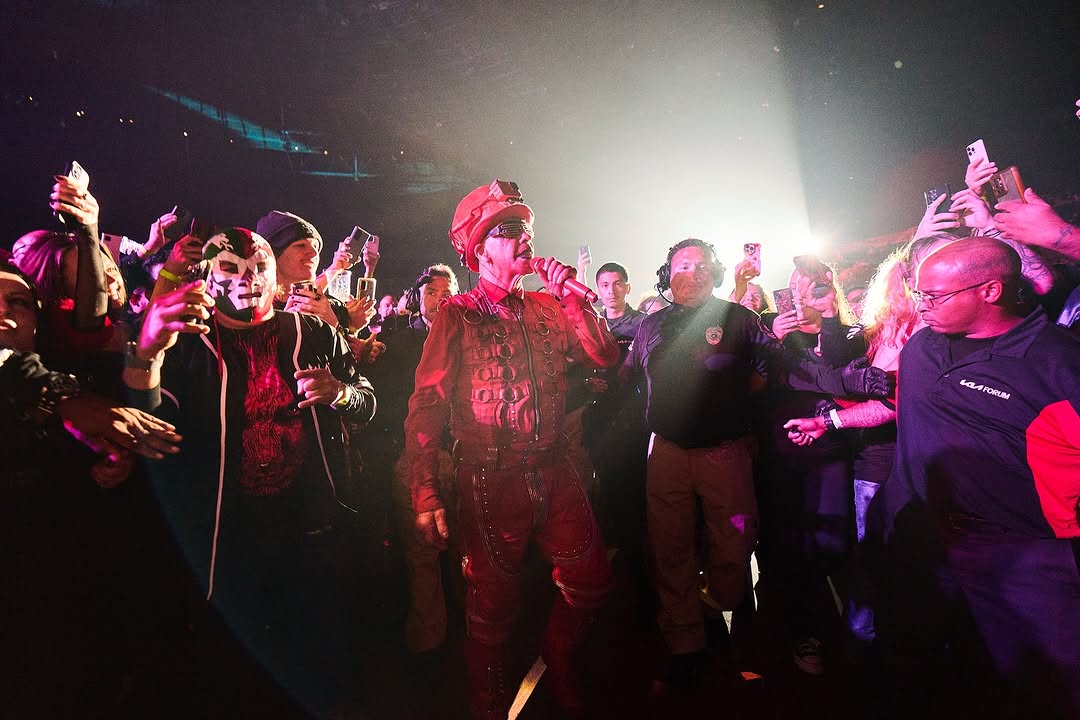 Till Lindemann walks through the crowd during a live performance dressed in a striking red outfit as fans capture the moment with their phones, Oct. 10, 2024. (Photo via Instagram / @till_lindemann_official)