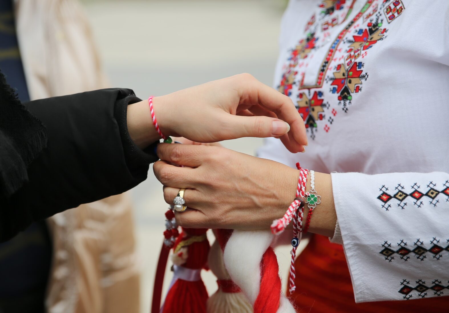 People tying martenitsa bracelets on each other's wrists, Edirne, Türkiye, March 1, 2025. (AA Photo)