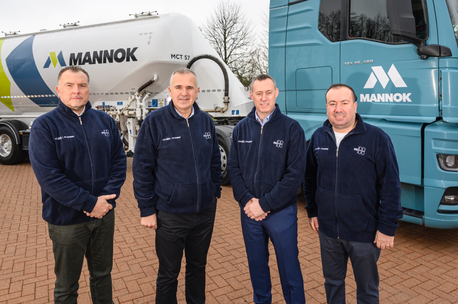 Sabanci Holding Materials Technologies Group President Burak Orhun (left), Sabanci Holding CEO Cenk Alper (second from left), Mannok Holdings CEO Dara O'Reilly (second from right), and Cimsa CEO Umut Zenar (right) pose in front of a Mannok truck in Dublin, Ireland, on Mar. 13, 2025. (AA Photo)