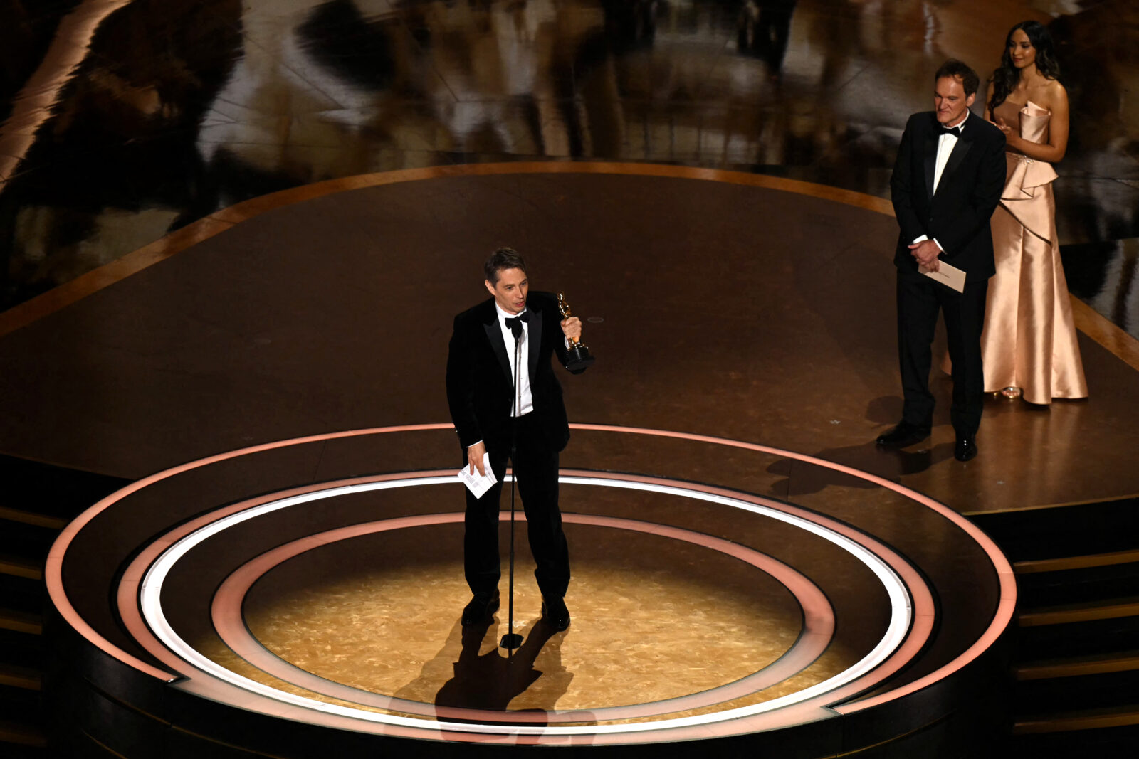 U.S. director Quentin Tarantino listens as U.S. producer and director Sean Baker accepts the award for best director for 