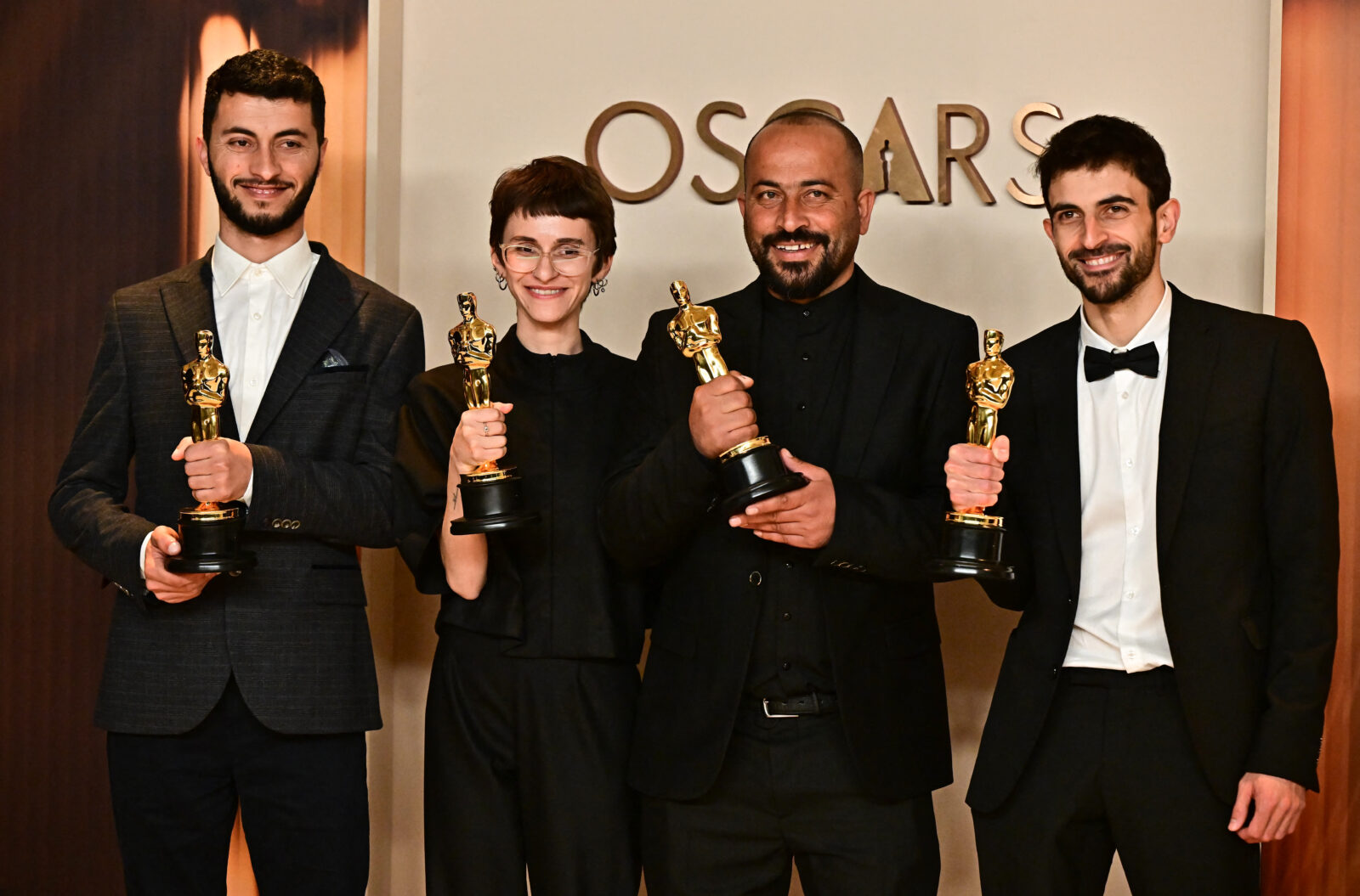 (L/R) Journalist and filmmaker Yuval Abraham, U.S. producer Rachel Szor, Emirati filmmaker Hamdan Ballal, Palestinian journalist and filmmaker Basel Adra pose in the press room with the Oscar for best documentary feature for 