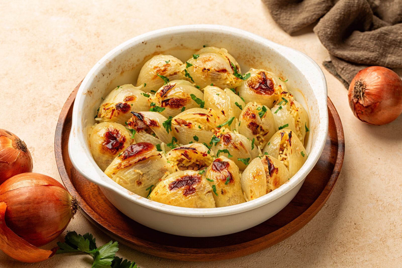 Sweet onions softened and baked until golden, stuffed with a herb-laced bulgur mix and arranged tightly in a white dish—an earthy, filling side dish common in Turkish home kitchens during Ramadan. (Adobe Stock Photo)