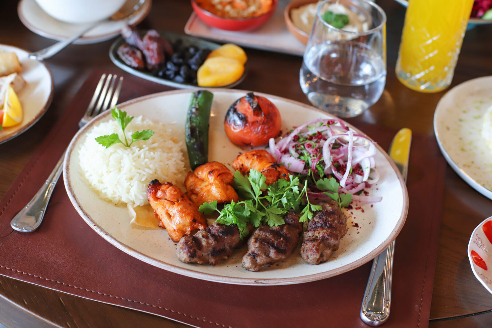 Adana kebab is a spicy grilled meat dish served with sumac onions, rice, and vegetables for a hearty iftar. (Adobe Stock Photo)