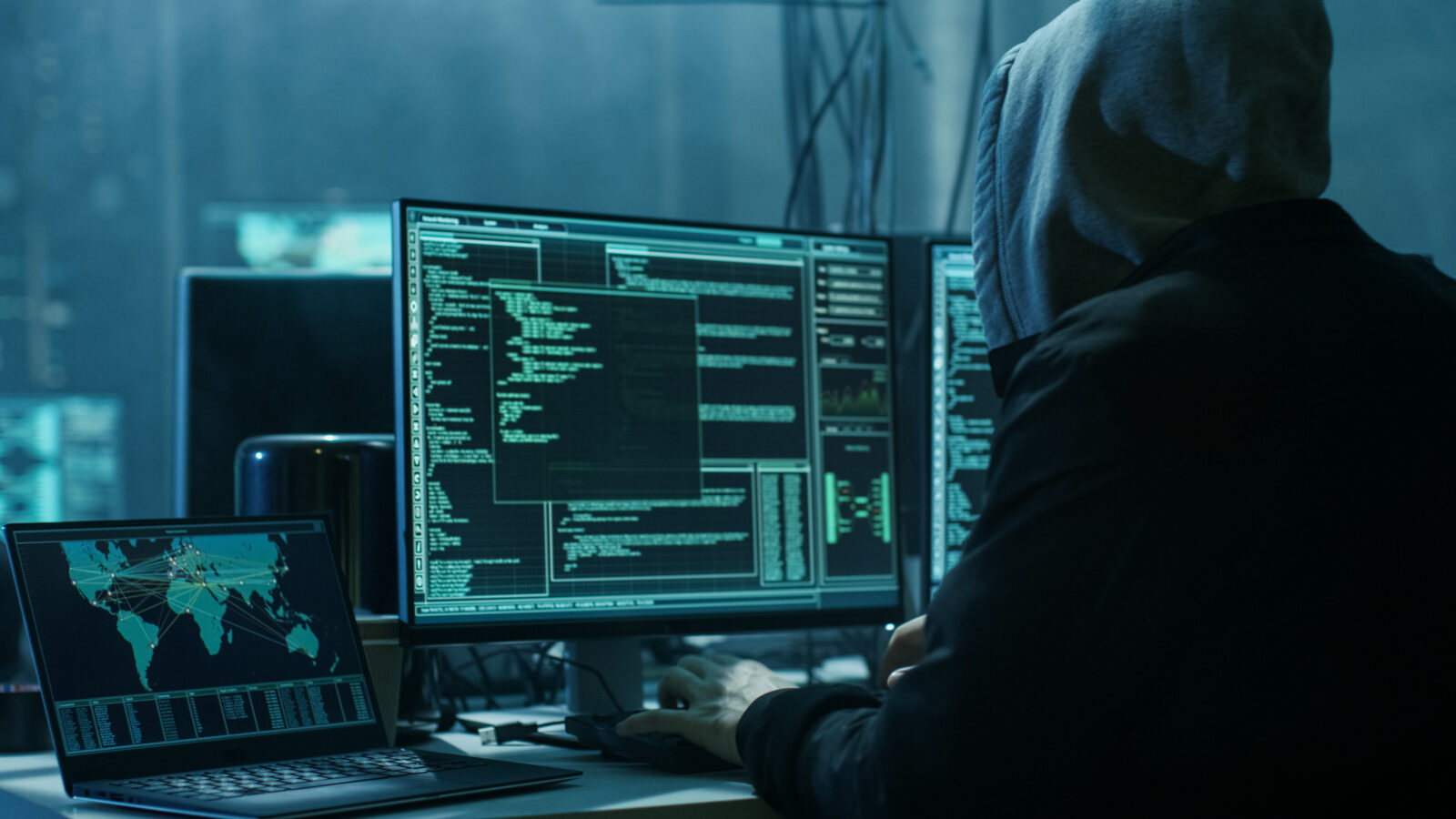 Hooded person using a computer (Adobe Stock Photo)