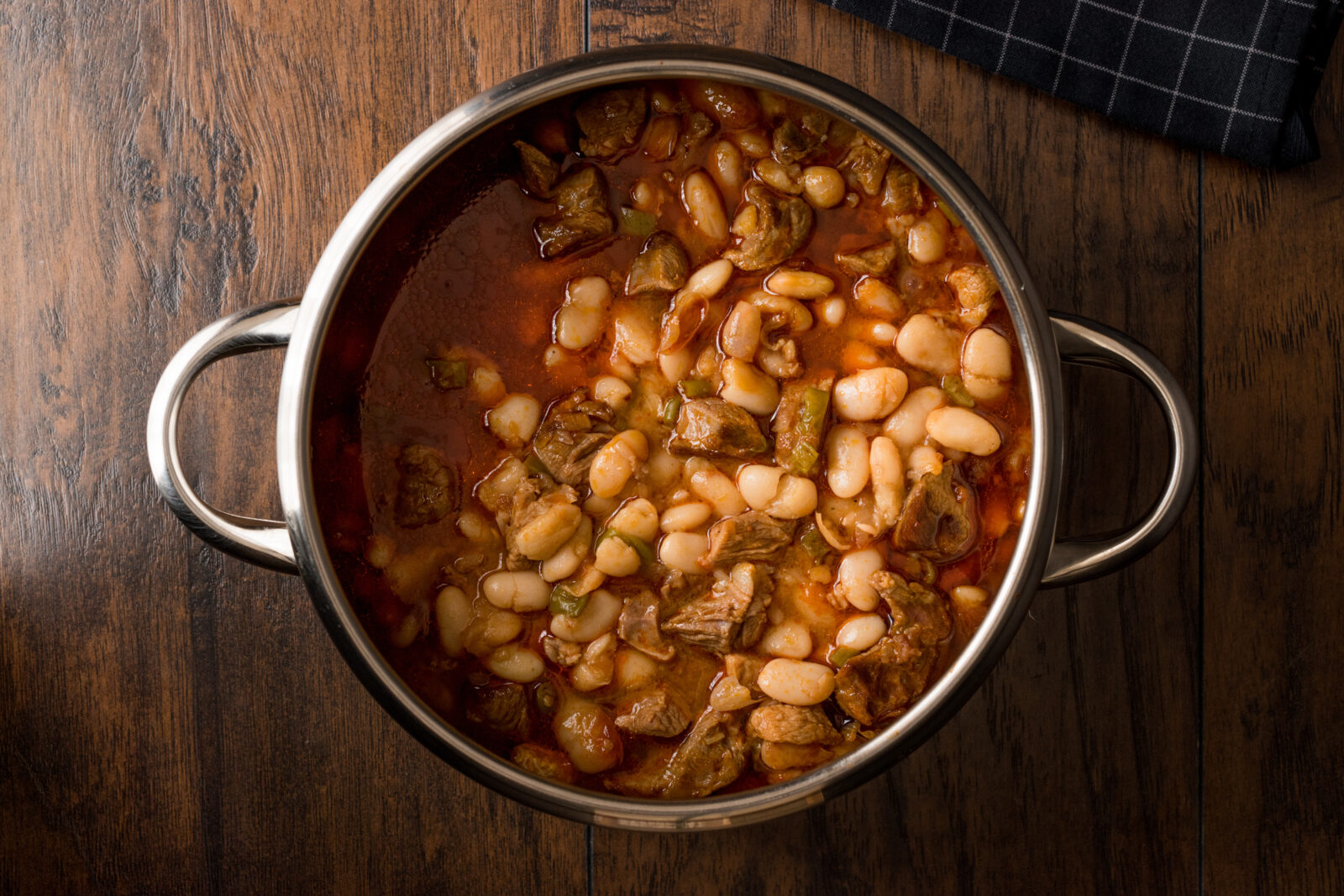 A pot of etli kuru fasulye, with tender chunks of lamb and white beans simmered in a rich tomato-based broth, a classic main dish in many Turkish homes during iftar. (Adobe Stock Photo)