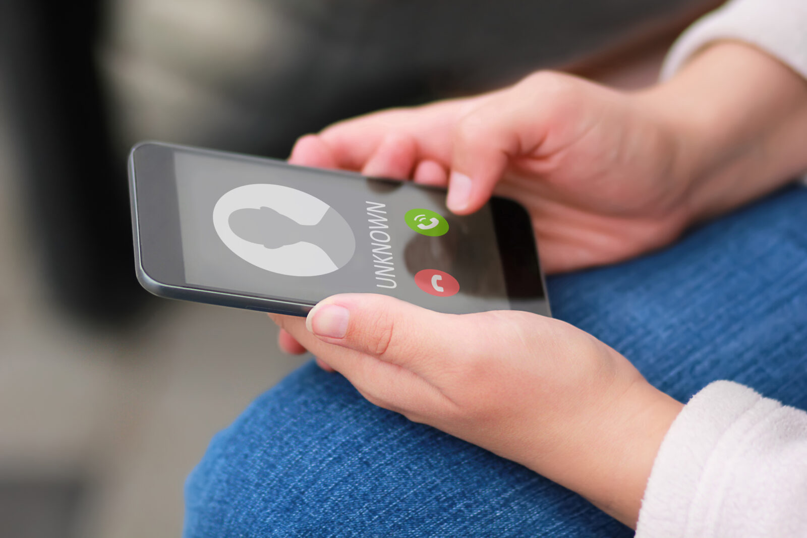 Close up of woman's hands with smartphone and unknown incoming phone call on it, fraud or scam schemes. (Adobe Stock Photo)