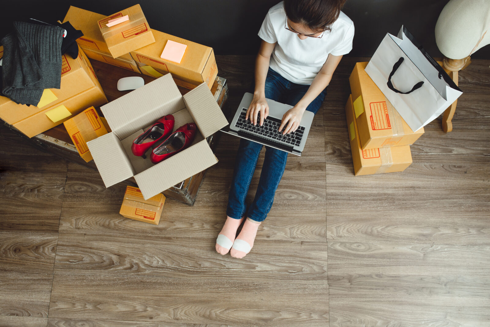 A woman surrounded by delivery boxes shops from home, a common practice addressed by the new law. (Adobe Stock Photo)