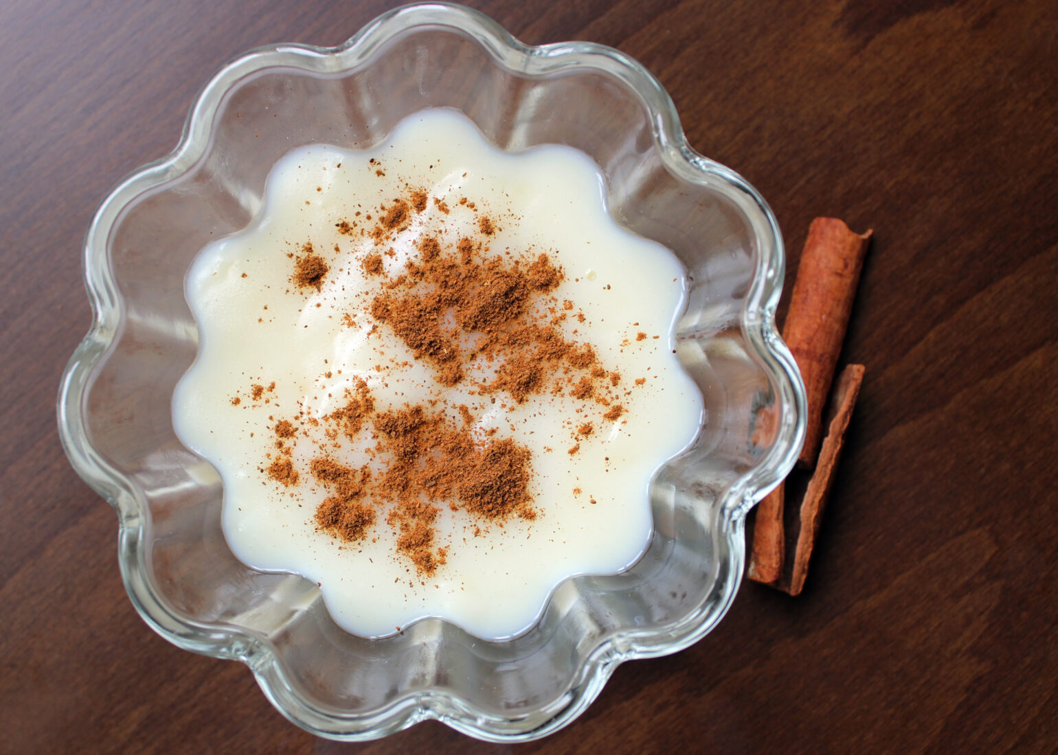 Chilled sakizli muhallebi topped with cinnamon, served in a scalloped glass bowl, offering a cool and fragrant finish to a rich iftar meal. (Adobe Stock Photo)