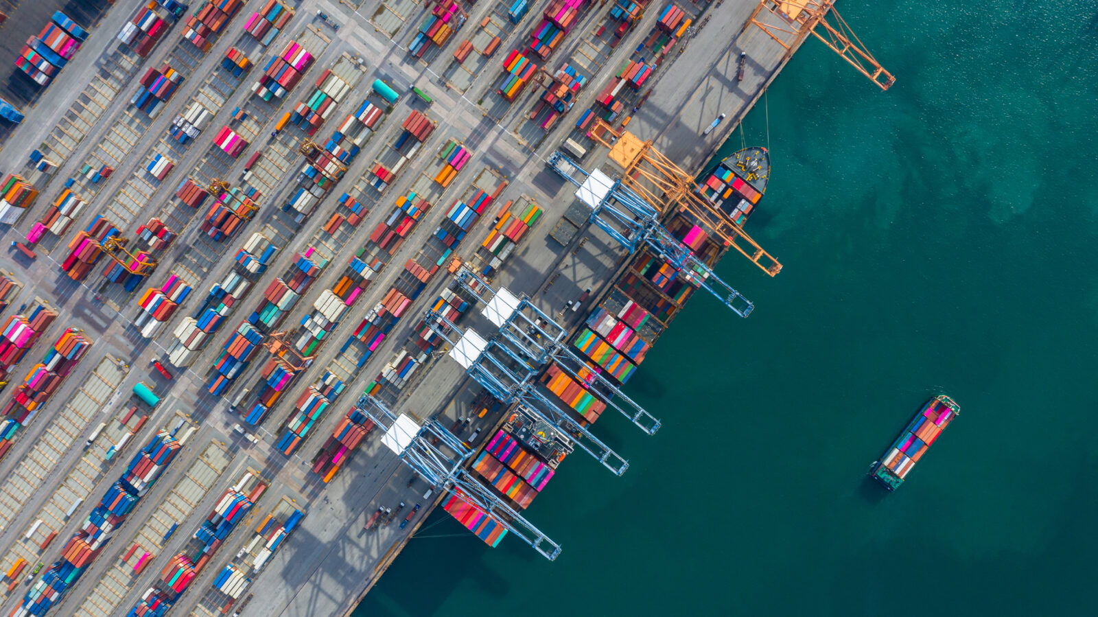 File photo shows an aerial view of an industrial port with containers and a container ship. (Adobe Stock Photo)