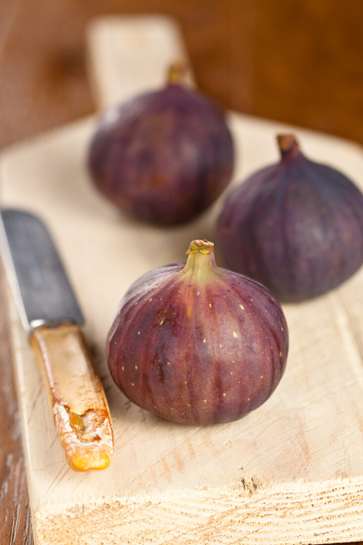 Freshly picked Bursa's black figs rest on a cutting board. (Adobe Stock Photo)Whole and sliced Bursa's black figs displayed on a wooden board. (Adobe Stock Photo)