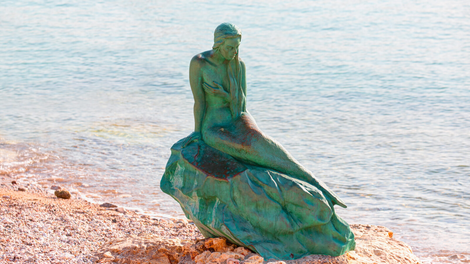 A mermaid statue looks over the Mediterranean from the rocky shores of Tasucu, a quiet coastal town in Mersin, Türkiye. (Adobe Stock Photo)