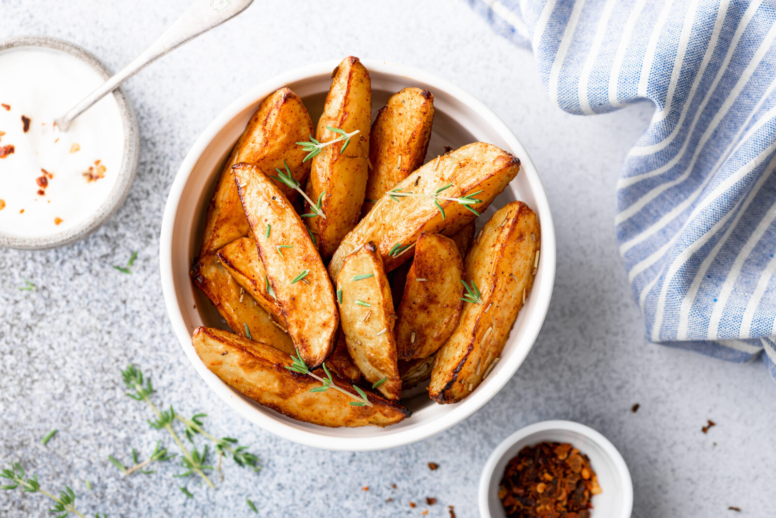 Crispy oven-baked potato wedges seasoned with sumac and thyme, an easy side dish to enjoy after breaking fast. (Adobe Stock Photo)