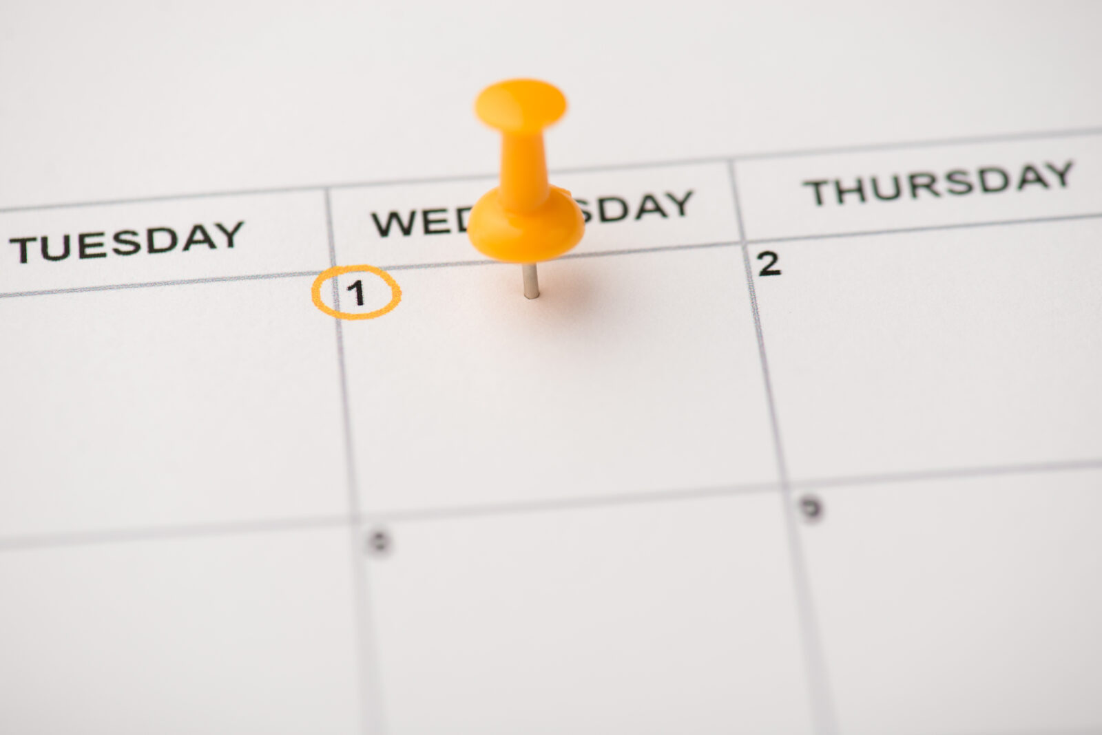 Close-up photo of a calendar marked on Wednesday the first with a yellow pushpin, with space. (Adobe Stock Photo)