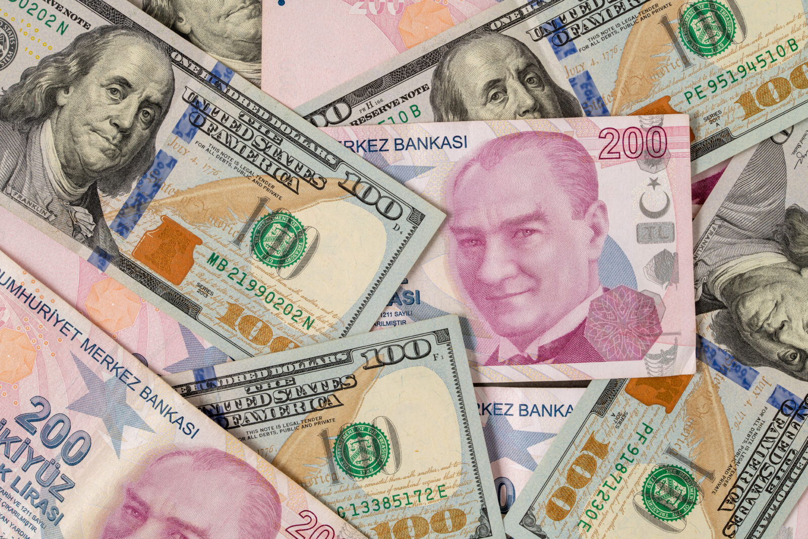 The image illustrates stacked U.S. dollar and Turkish lira banknotes, accessed on Mar. 21, 2025. (Adobe Stock Photo)