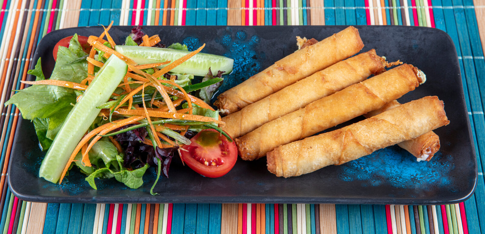 Crispy Turkish sigara boregi served with a fresh salad for a delicious iftar appetizer. (Adobe Stock Photo)