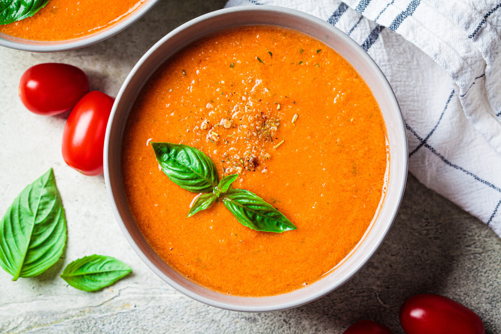 A bowl of Turkish tomato soup garnished with fresh basil and spices, perfect for iftar. (Adobe Stock Photo)