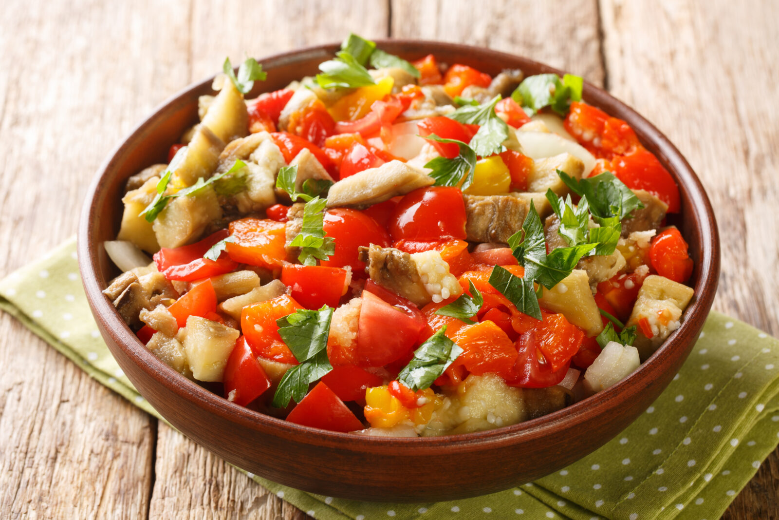 Grilled eggplant salad with tomatoes and peppers, a smoky and refreshing side dish for an iftar meal. (Adobe Stock Photo)