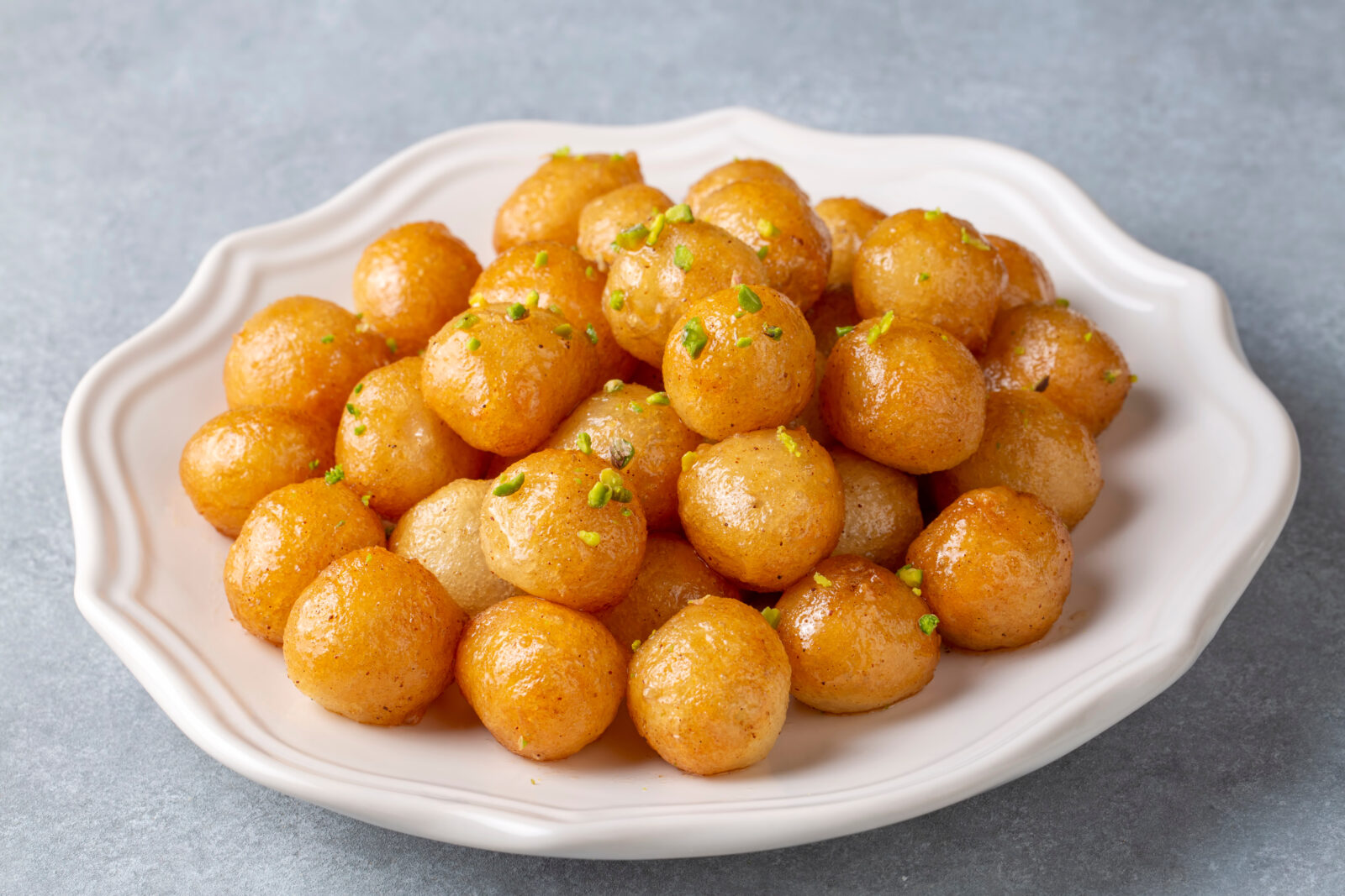 Golden, crispy lokma drizzled with syrup, a beloved Turkish dessert often enjoyed during iftar. (Adobe Stock Photo)