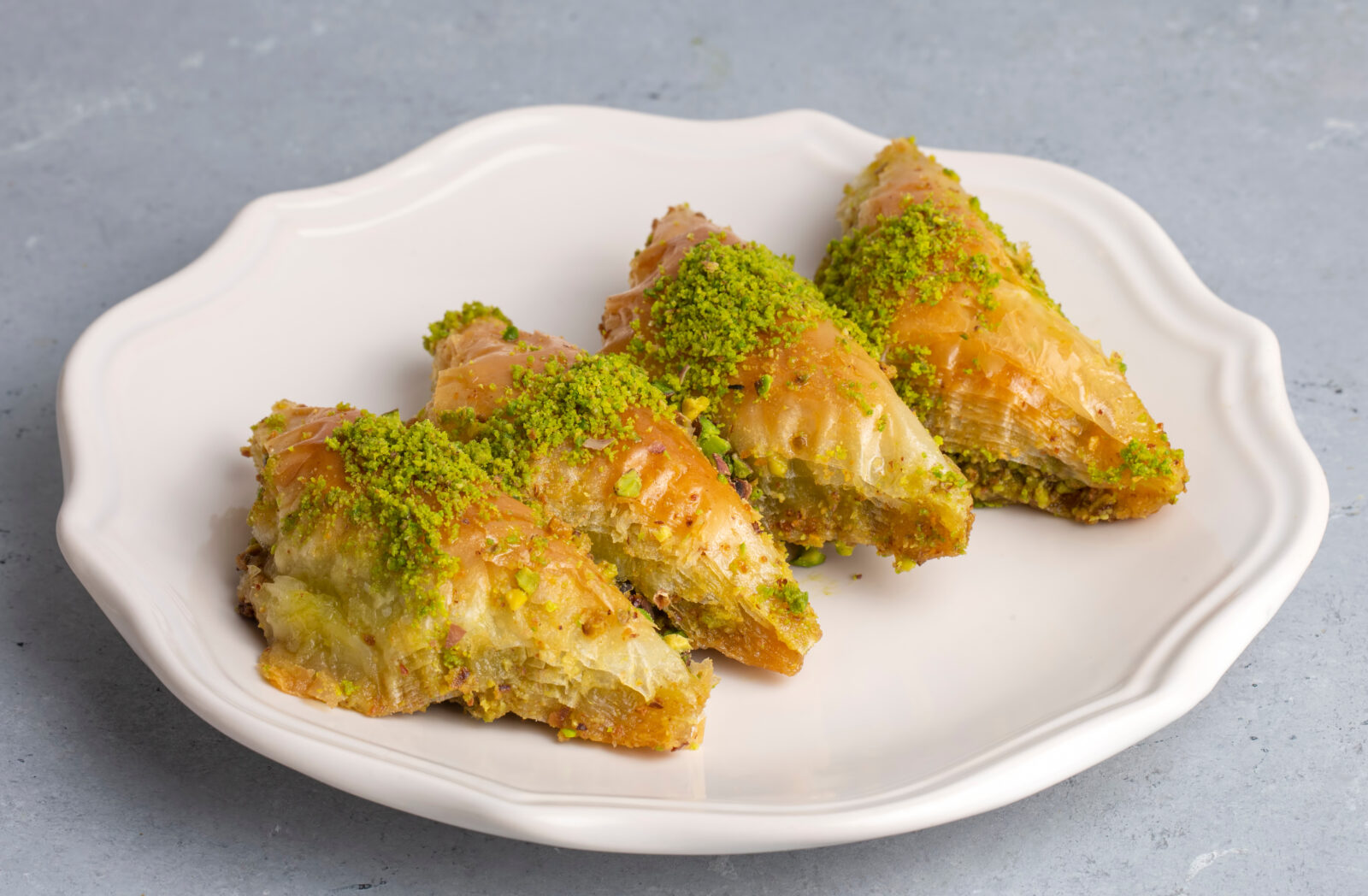 A plate of syrup-soaked Sobiyet pastry filled with semolina and cream, topped with crushed pistachios. (Adobe Stock Photo)