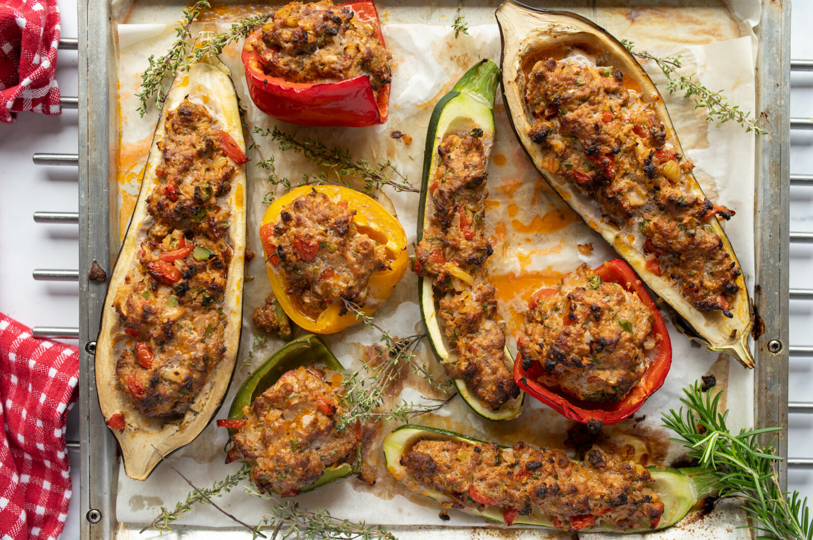A tray of oven-baked stuffed eggplants and bell peppers with seasoned ground meat and melted cheese. (Adobe Stock Photo)