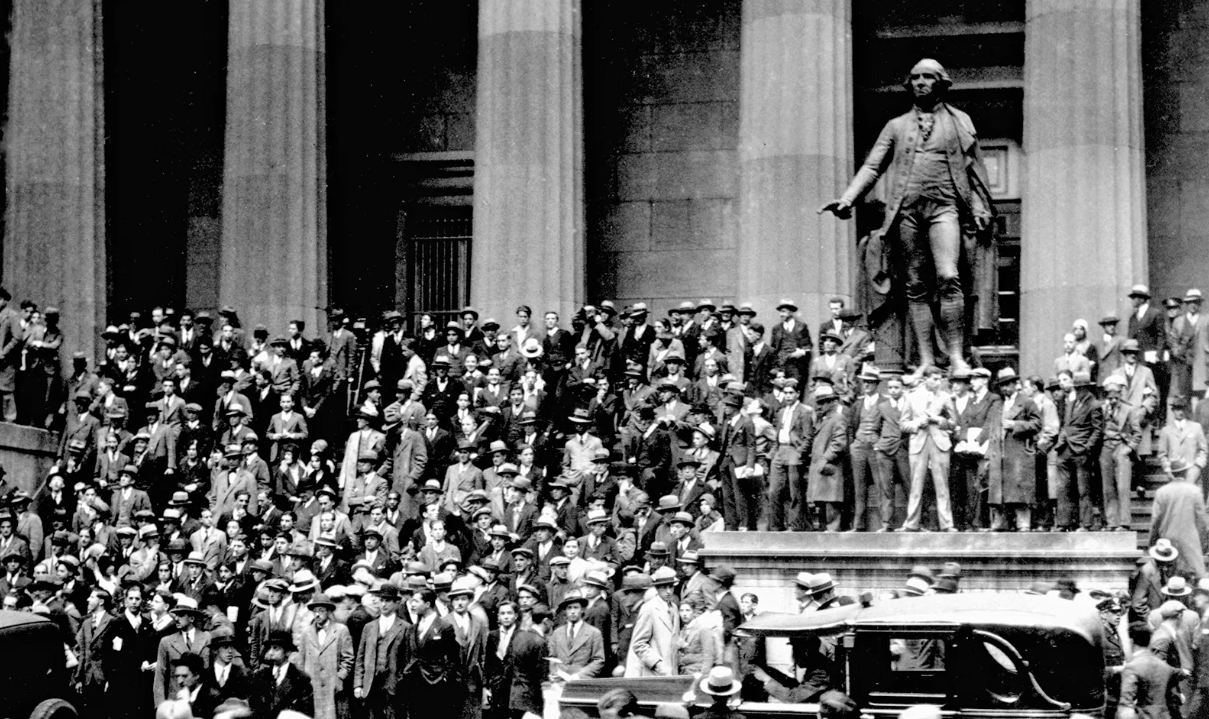 People gather on the steps of the building across from the New York Stock Exchange on Black Thursday, the start of the stock market crash of 1929, Oct. 24, 1929. (Photo via Hulton Archive)