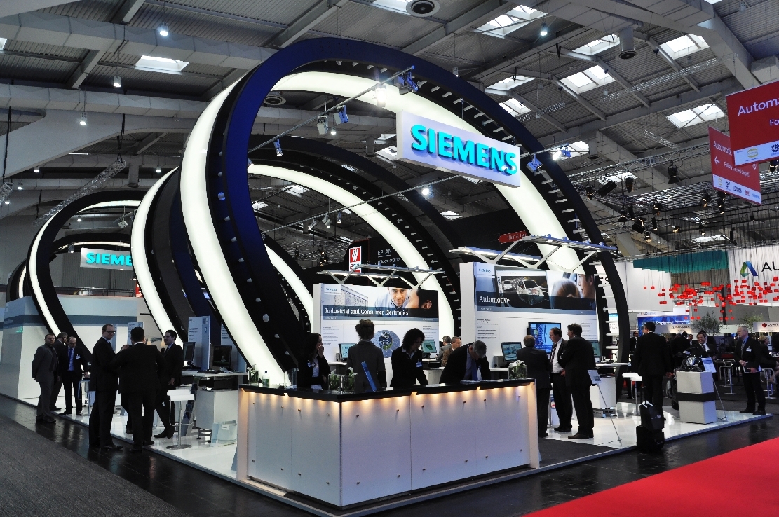 Visitors engage with company representatives at the Siemens booth during the Hannover Messe fair in Hanover, Germany, on Apr. 12, 2014. (Photo via wikipedia.org)