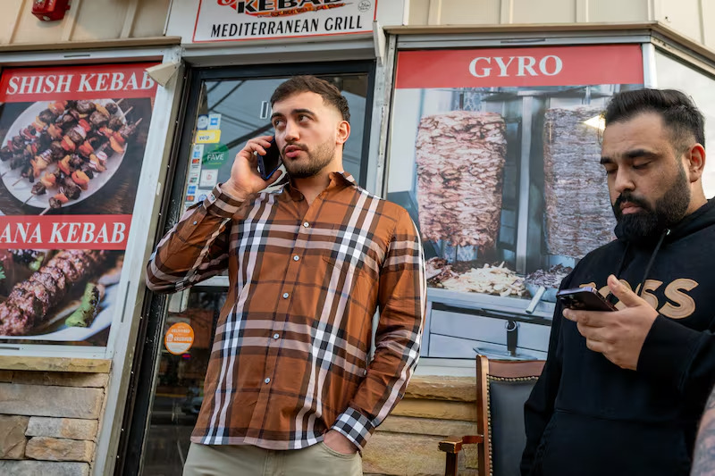 Muhammed Emanet (L) speaks to his father on the phone as he returns to the Jersey Kebab restaurant in Haddon Township. (Photo via Inquirer)