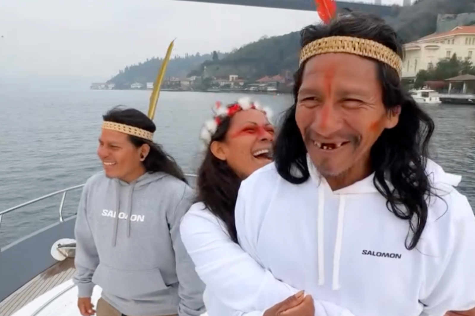 Waorani tribe members share laughter on a boat while exploring Türkiye, wearing traditional feathered headbands, Istanbul, Türkiye, Feb. 4, 2025. (Photo via Instagram / @alperrende)