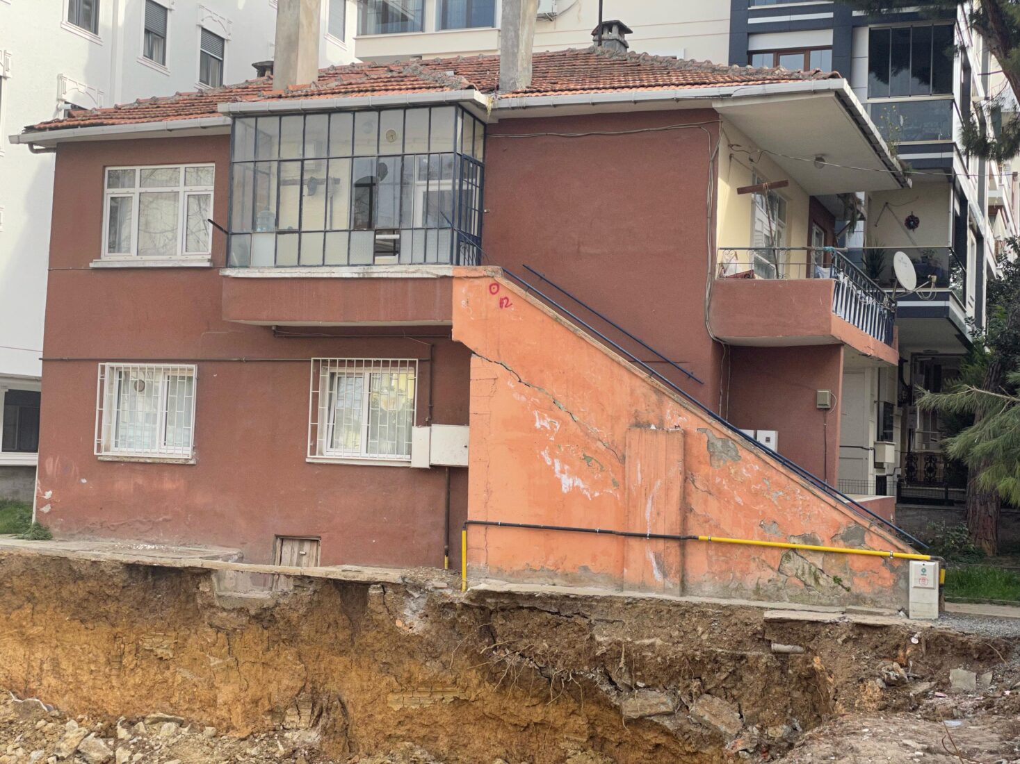After the foundation was dug for a demolished building as part of urban transformation in Istanbul, Türkiye, cracks in the stairs of an adjacent building and subsidence below can be seen. (Photo via Koray Erdogan/Türkiye Today)